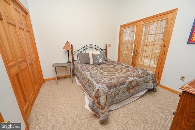 bedroom featuring a closet, access to outside, light colored carpet, and french doors