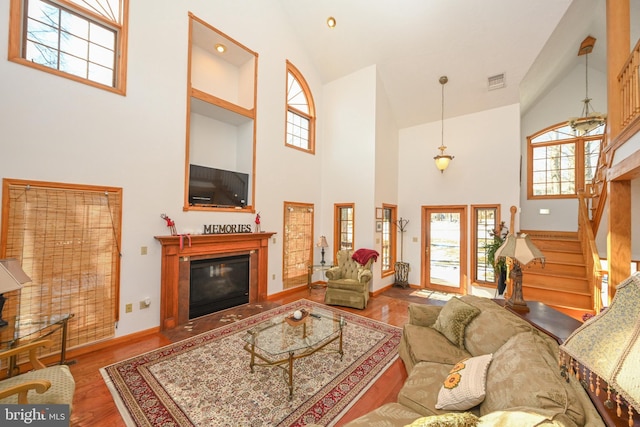 living room with hardwood / wood-style flooring and a towering ceiling