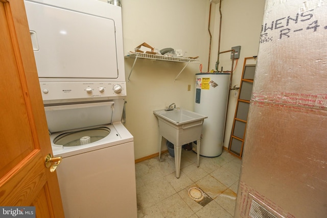 washroom with sink, electric water heater, and stacked washer / dryer