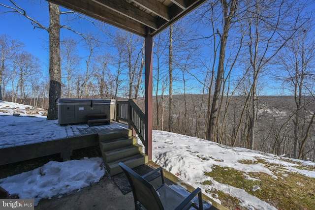 snow covered deck featuring a hot tub