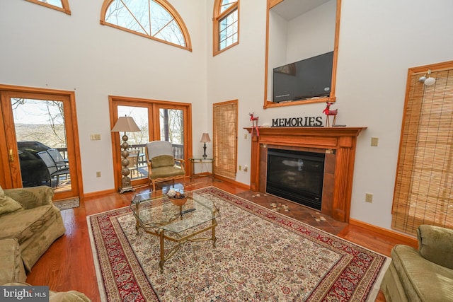 living room with hardwood / wood-style flooring, a high ceiling, and french doors