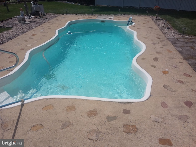 view of pool featuring a lawn