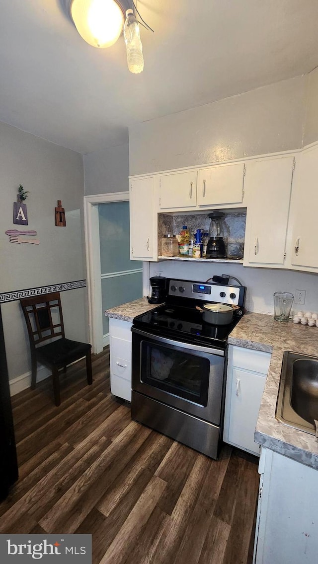 kitchen with stainless steel electric range oven, dark wood-type flooring, sink, and white cabinets