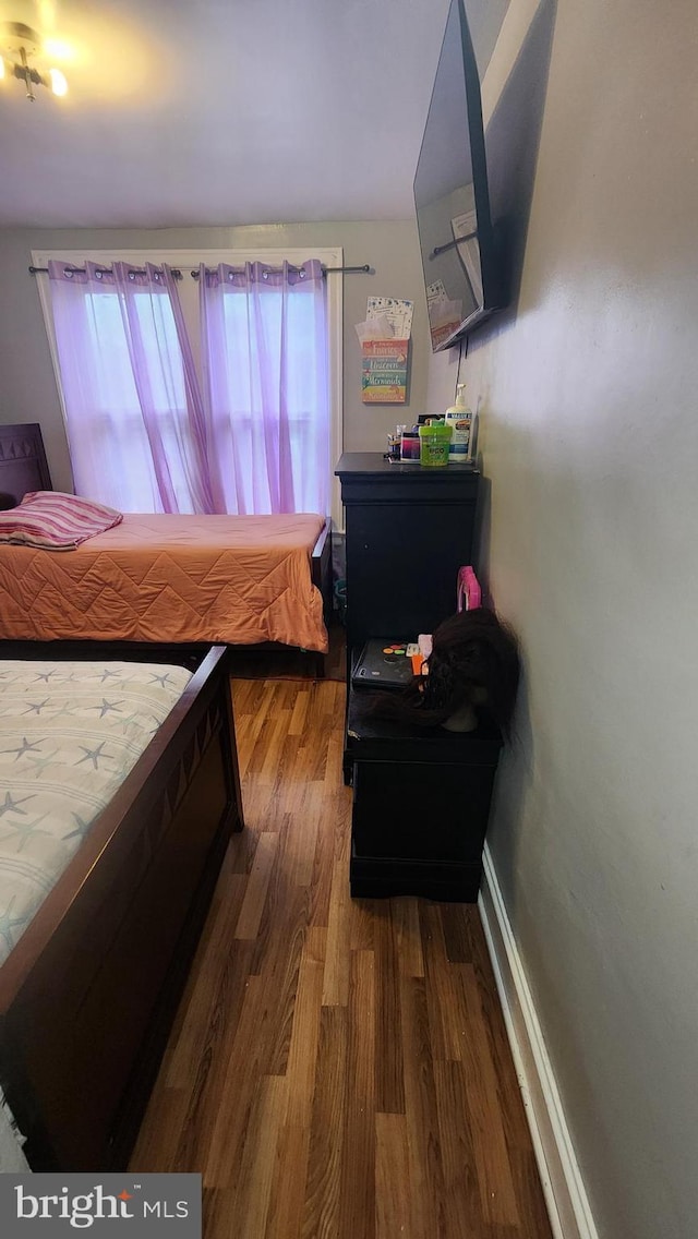 bedroom with dark wood-type flooring and multiple windows