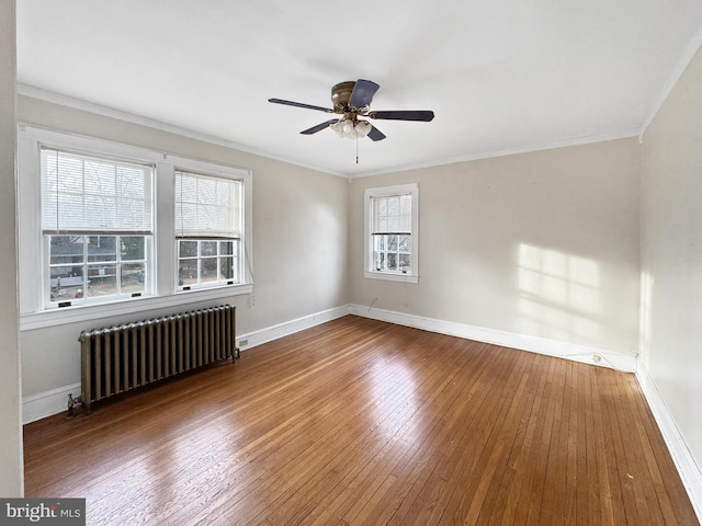 unfurnished room with ceiling fan, ornamental molding, radiator heating unit, and wood-type flooring