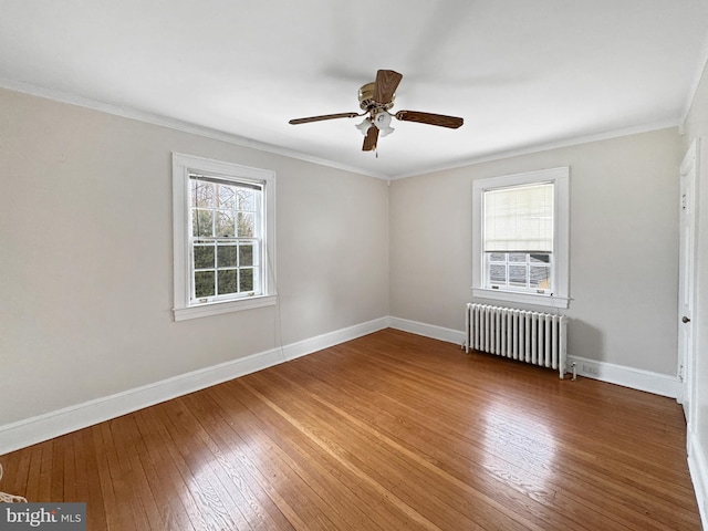 spare room featuring crown molding, wood-type flooring, and radiator