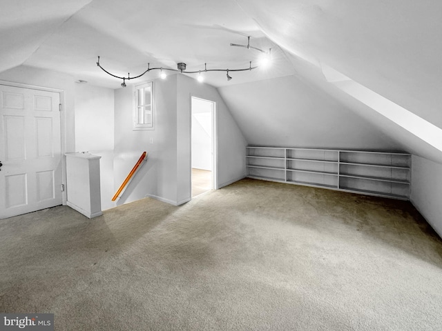 additional living space featuring lofted ceiling and carpet flooring