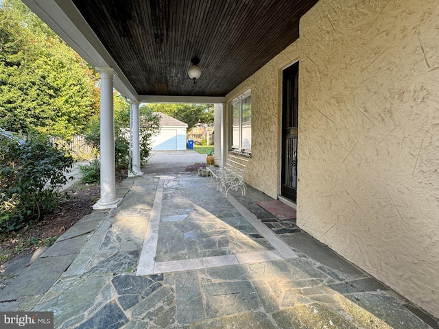 view of patio / terrace with a garage and an outdoor structure