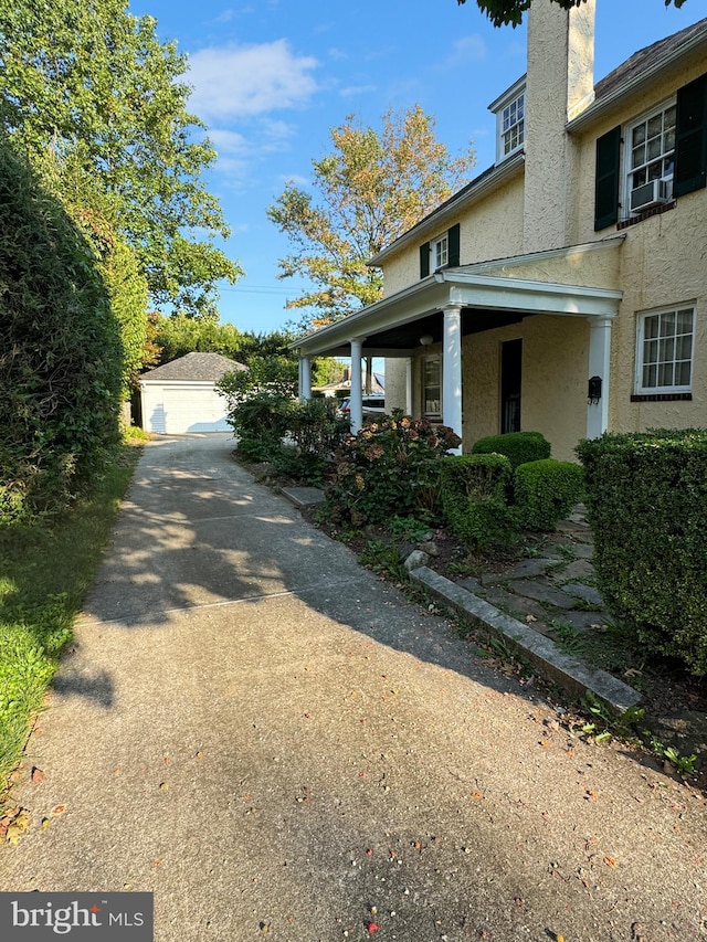 view of home's exterior featuring an outbuilding, a garage, and covered porch