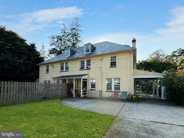 back of house with a lawn and a carport