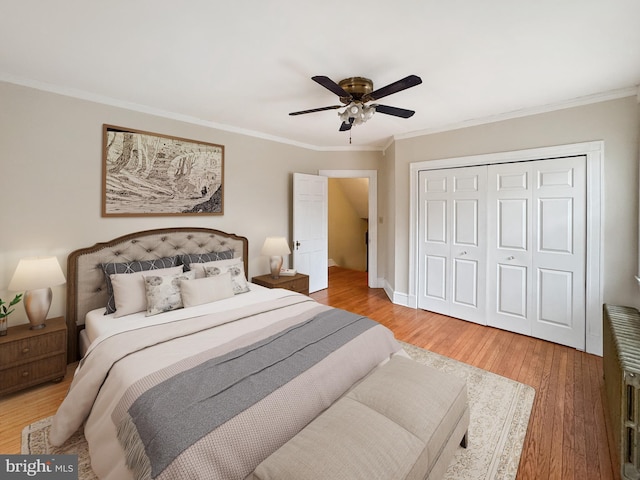 bedroom with crown molding, ceiling fan, wood-type flooring, and a closet