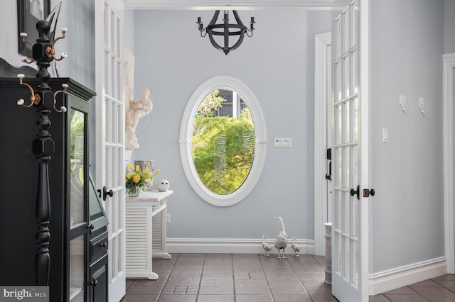 tiled foyer featuring a chandelier