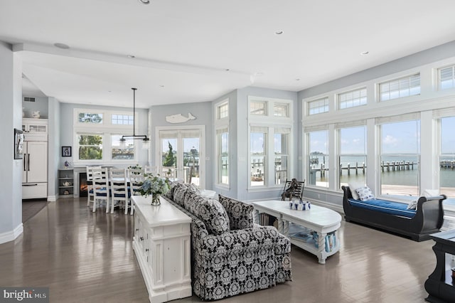 living room featuring a water view and dark hardwood / wood-style floors