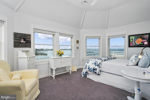 bedroom featuring dark carpet, vaulted ceiling, and a water view