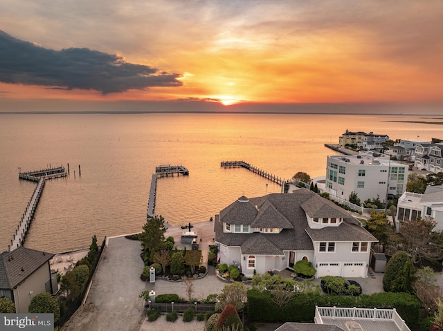 aerial view at dusk featuring a water view