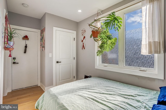 bedroom with multiple windows and light wood-type flooring