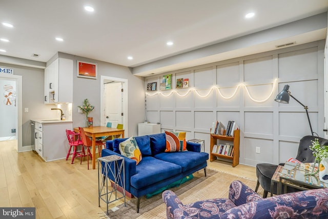 living room featuring sink and light wood-type flooring