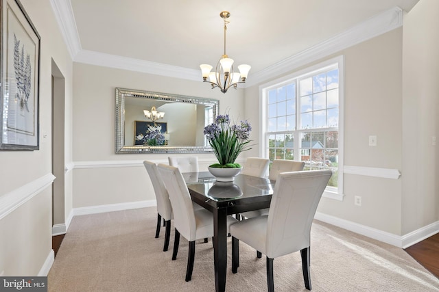 carpeted dining area with an inviting chandelier and ornamental molding