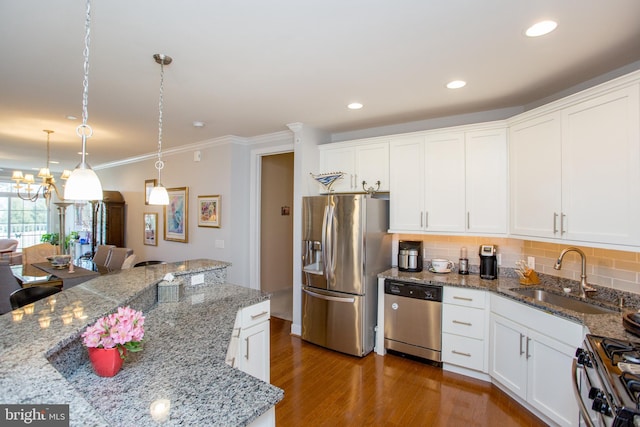 kitchen with stone counters, pendant lighting, white cabinetry, sink, and stainless steel appliances