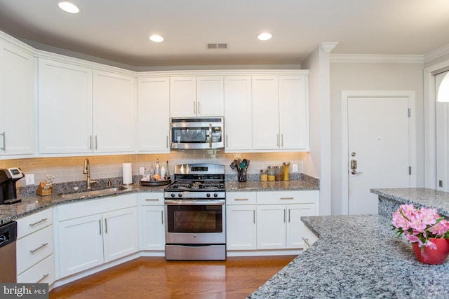 kitchen with light stone counters, sink, stainless steel appliances, and white cabinets