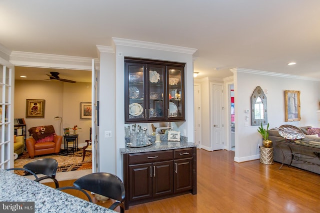 interior space with ceiling fan, ornamental molding, and light hardwood / wood-style flooring