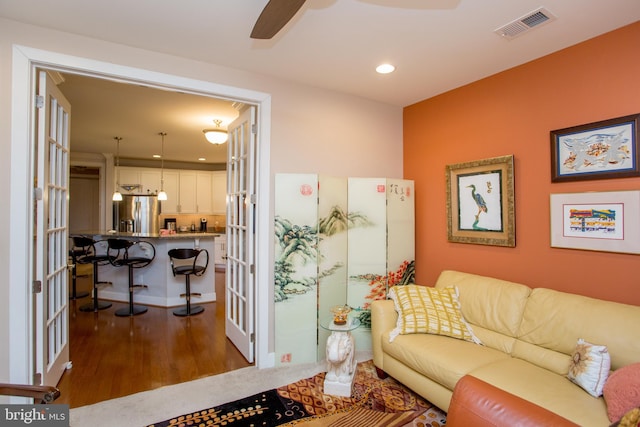 living room with dark wood-type flooring and ceiling fan