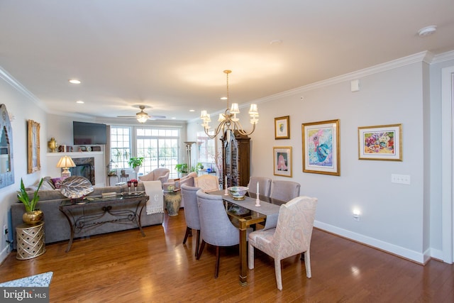 dining room featuring a premium fireplace, crown molding, hardwood / wood-style floors, and a notable chandelier