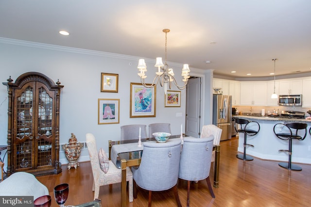 dining area featuring crown molding, hardwood / wood-style floors, and a chandelier