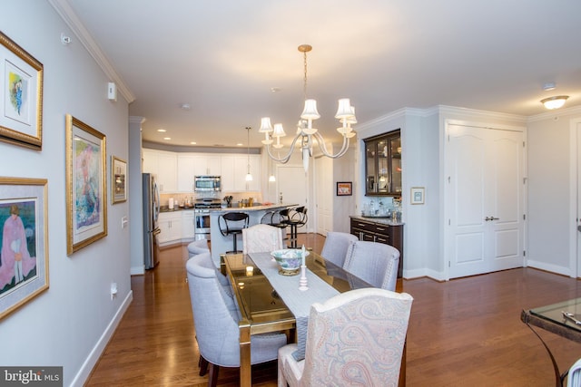 dining area with crown molding, dark hardwood / wood-style flooring, and a chandelier