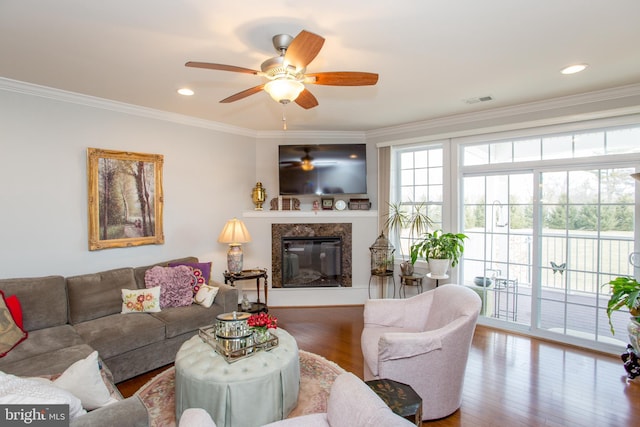 living room featuring crown molding, ceiling fan, a fireplace, and hardwood / wood-style flooring