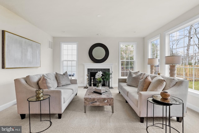 carpeted living room featuring a premium fireplace