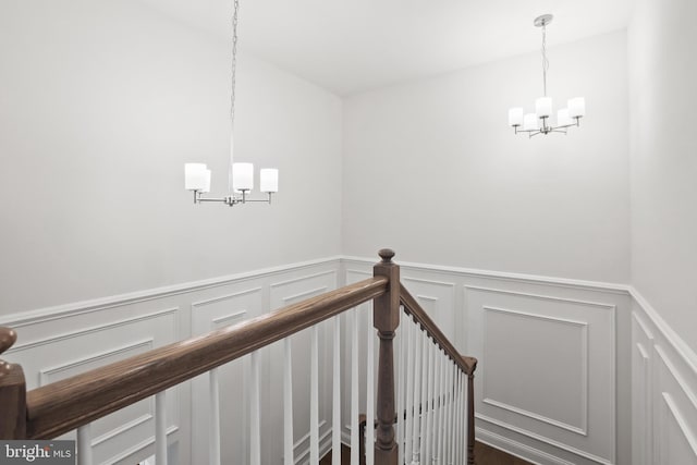 14496 Aurora Dr, Woodbridge, VA 22193 - staircase with a chandelier, a decorative wall, and wainscoting