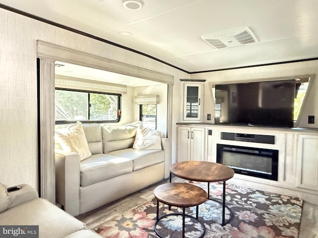 living room with crown molding and light wood-type flooring