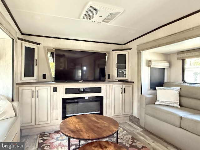 living room with crown molding and light hardwood / wood-style floors