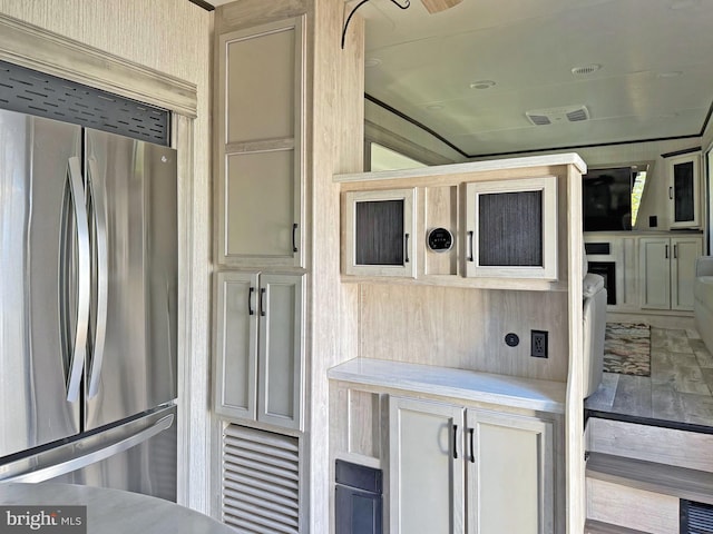 kitchen with cream cabinets and stainless steel fridge