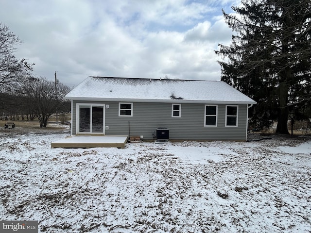 snow covered back of property with central AC unit