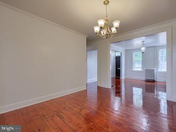 519 Locust St, Columbia, PA 17512 - unfurnished dining area featuring a chandelier, ornamental molding, baseboards, wood finished floors, and radiator