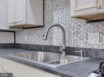 519 Locust St, Columbia, PA 17512 - kitchen view of white cabinets, decorative backsplash, a sink, and dark countertops