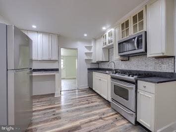 519 Locust St, Columbia, PA 17512 - kitchen featuring appliances with stainless steel finishes, dark countertops, open shelves, glass insert cabinets, and a sink