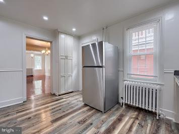 519 Locust St, Columbia, PA 17512 - kitchen with freestanding refrigerator, radiator heating unit, a chandelier, wood finished floors, and recessed lighting