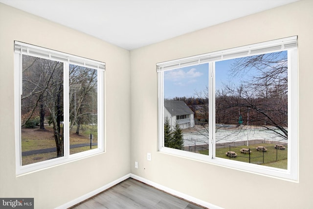 empty room with a healthy amount of sunlight and hardwood / wood-style floors