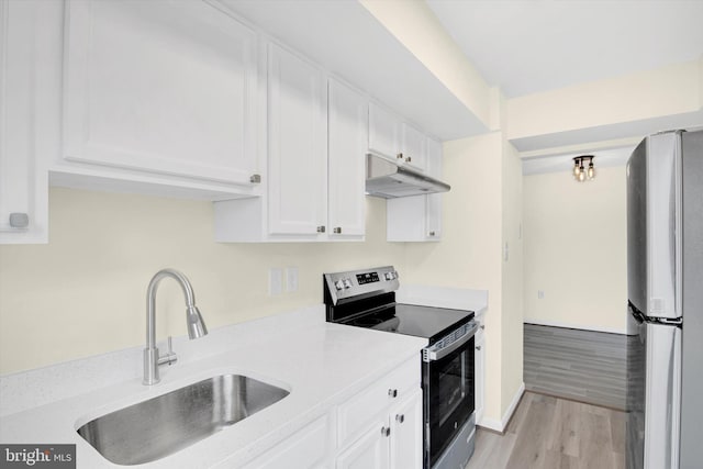 kitchen featuring stainless steel appliances, white cabinetry, sink, and light wood-type flooring