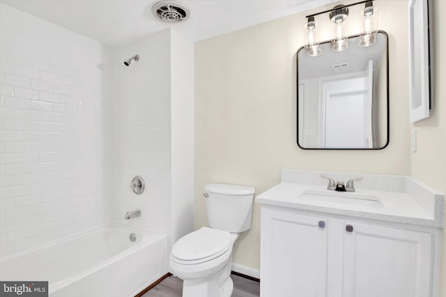 full bathroom with tiled shower / bath, wood-type flooring, vanity, and toilet