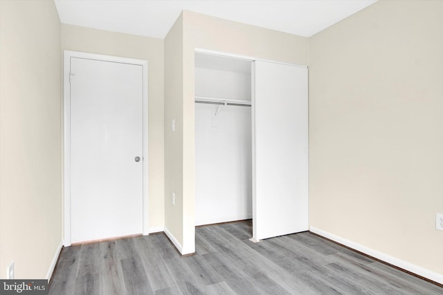 unfurnished bedroom with light wood-type flooring and a closet