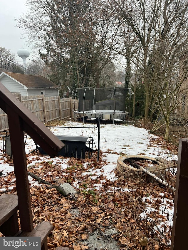 yard covered in snow with a trampoline