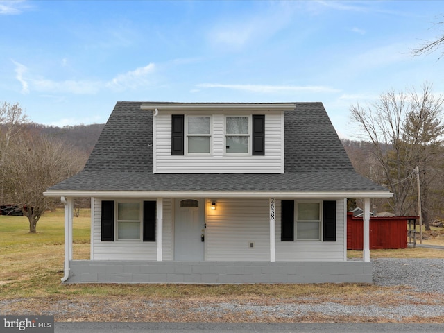 farmhouse featuring a porch and a front yard