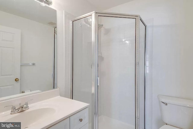 bathroom featuring vanity, an enclosed shower, and toilet