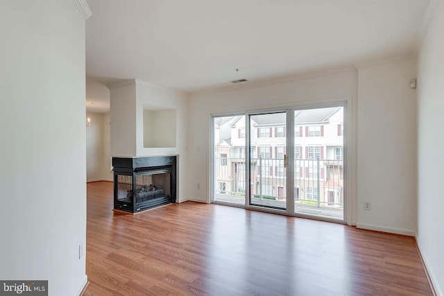 unfurnished living room with crown molding, a multi sided fireplace, and light hardwood / wood-style floors