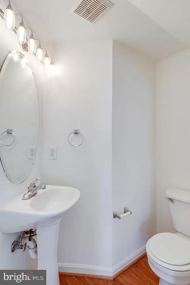 bathroom with hardwood / wood-style flooring and toilet