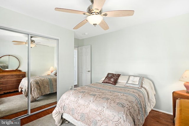 bedroom with ceiling fan, dark hardwood / wood-style flooring, and a closet